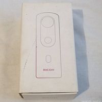 White box with Ricoh Theta SC2 camera image on top, showing slight wear and scuff marks.