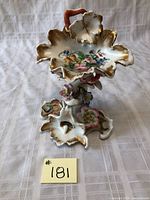 Full view of antique scalloped porcelain dish with gilded edges, floral hand-painted design on top, ornate base with small flower decorations and curved handle.