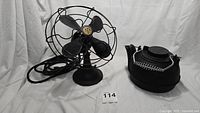 Robbins & Myers electric desk fan beside cast iron tea kettle on white backdrop, showing the full lot.