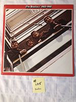 Front cover of The Beatles 1962-1966 album featuring band looking down from balcony.