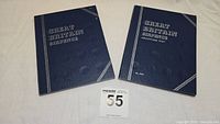 Two blue collector albums labeled 'Great Britain Sixpence' showing the collection is housed in albums.