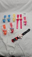 Overview of eight Kelloggs cereal character watches in various colors including Snap, Crackle, Pop, Tony the Tiger, Toucan Sam as well as an Air Canada airplane watch with black strap and red accents.
