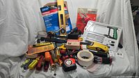 Full view of the assortment of tools including screwdrivers, hand saw box, level, tape, and other tools