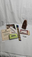 Photo showing two vintage tin whistles, beginner instruction books and cassette tape along with Wittner Prazision Taktell Piccolo metronome.