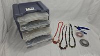 Kit overview showing storage case, necklaces/strands, pliers, and wire spools.