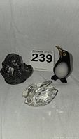 Photo of three miniature sculptures: soapstone bear cubs, soapstone penguin with brass beak, and Swarovski crystal swan