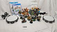 View of the full Skylanders Swap Force collection including character figures arranged in middle with two portals of power bases on either side and two video game cases behind.