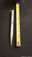 Mechanical pencil shown next to a tape measure indicating length about 5 1/8 inches.