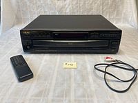 Front view of TEAC PD-D2500 CD player with remote and audio cable on table