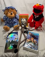 Full lot showing Berenstain Bears Mama Bear plush, Jack Skellington plush, Elmo plush, two VHS tapes and Winnie the Pooh book