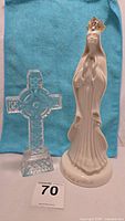 Photo of the Our Lady of Knock statue and the Waterford crystal Celtic cross together against a blue cloth background.