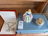 Full lot as presented on the jewellery box with necklace, brooch, figurine, and jar