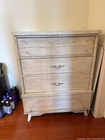 Front view of wooden dresser showing four drawers and handles.