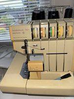 Front view of Pfaff serger showing body, tension dials and needle area