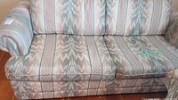 Front view of the sofa bed showing seat cushions and back cushions with patterned fabric upholstery