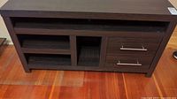 Front view of dark brown wooden TV stand with two drawers and multiple open shelves