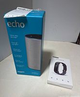 Photo of Amazon Echo and Smarttrack fitness tracker in their original packaging on a white table.
