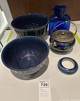 Full view of all five blue themed items, including two ceramic bowls, glass vase, decorative pot, and small glass bowl.