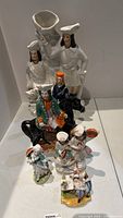 Group photo showing all six assorted ceramic figurines together on white surface.