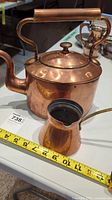 Photo of the copper kettle and Turkish coffee dipper showing the full kettle with lid and the dipper alongside it with measuring tape for scale.