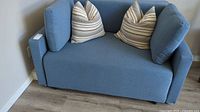 Front view of blue sofa bed with striped accent pillows