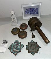 South Asian collectible items including brass Buddhist prayer wheel, brass decor pieces, ceramic figurine, and an art card.