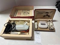 Vintage electric shaver and hair clipper in original boxes with cords and accessories.
