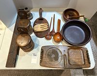 Overview of wooden serveware including bowls, platter, servers, salt boxes, ladle, mortar and pestle, and a carved wooden piece