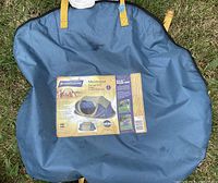 Carry bag of the Broadstone Montague 2-person pop-up tent. Bag is blue with yellow handles and a label showing the product photo and details.