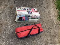Muskoka tent carrying bag alongside original box packaging on outdoor ground