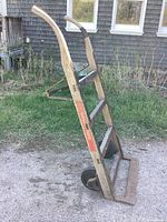 Side perspective of the antique wooden Fairbanks Morris hand cart showing wooden frame, metal wheels, and original branding label.