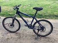 Left side view of blue Brodie mountain bike with front suspension, disc brakes, bottle cage and kickstand