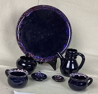 Front view of all seven pieces in the German 7-piece pottery set including cups, creamer, sugar bowl, plate, small lidded pot, and jug on neutral background.