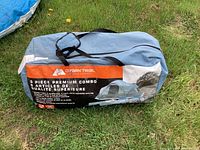 Blue and gray carry bag for a large tent with Ozark Trail branding, displayed on grass