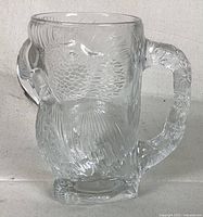 Front view of the large clear glass owl mug showing detailed owl face and textured feathers.