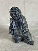 Front view of the Inuk soapstone walrus hunter sculpture showing detailed facial features, clothing, and a small tool or weapon in hand.