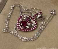 Coiled chain and heart pendant on display surface