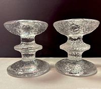Front and side view of the two clear textured glass candle holders showing their shape and texture.