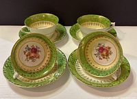 Four sets of vintage Royal Devon bone china teacups and saucers arranged for display showing floral designs, green and gold trim detail.