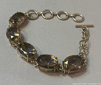 Full view of 9-inch silver bracelet with oval and teardrop mystic quartz stones and toggle clasp.