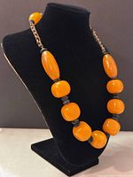 Front view of the chunky bead necklace displayed on black stand showing the size and bead shapes.