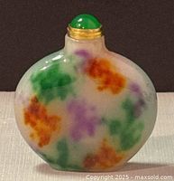Front view of oval flat perfume/snuff bottle made of multicolor jade with green jade stopper and metal collar