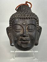 Front view of the bronze Buddha head showing facial features and forehead urna.
