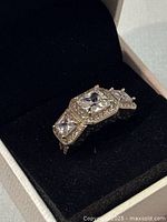 Close-up of the Pandora sterling silver ring with clear stones in its original box showing detailing and minor wear.