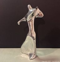 Front view of the signed Hoselton aluminum sculpture showing abstract golfer figure with curved and angled polished surfaces forming dynamic pose.
