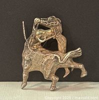 Front view of the silver matador and bull brooch showing detailed craftsmanship.