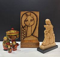 Group photo showing all four folk art items: painted bowl, nesting dolls, carved figurine group, and wooden plaque