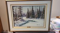 Full view of the framed painting depicting a snowy wooded landscape with a water body.