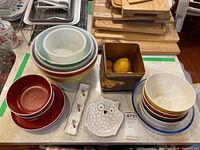 Top view of assorted bowls, tin container with faux fruit, porcelain dish, and owl trinket dish on table