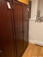 Wood cabinet front view showing two closed paneled doors with round handles